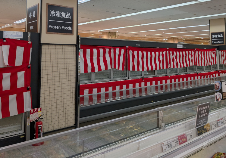 空になった冷凍食品の棚に紅白幕が張られている様子